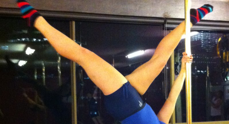 PoleFit student Chelsea Booth demonstates an Advanced Pole Dance skill called "Extended Butterfly"